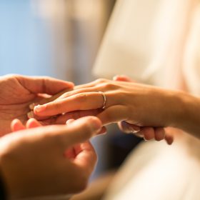 結婚式で結婚指輪を新婦にはめる新郎