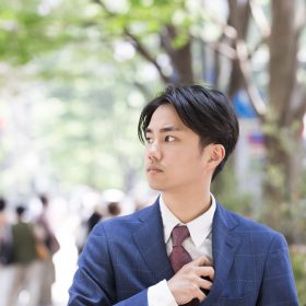 街路樹を歩くビジネスマン