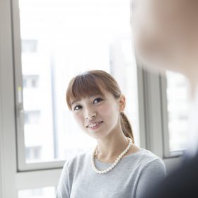 窓際で男性を見ている女性