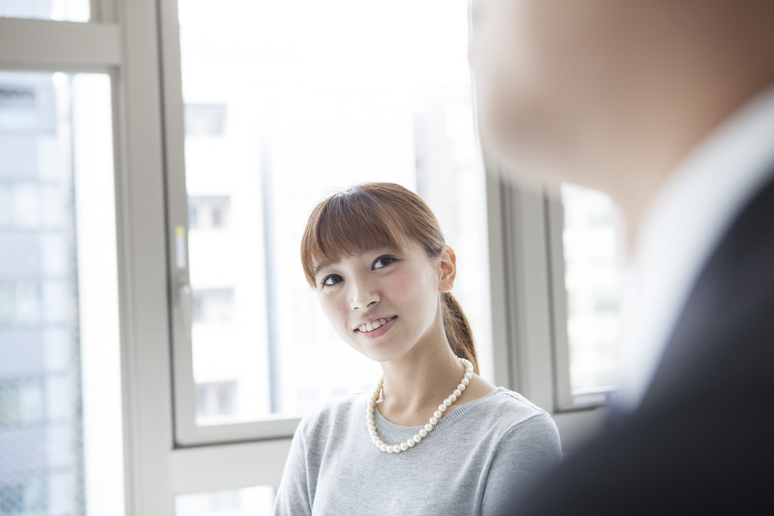 窓際で男性を見ている女性