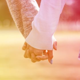 公園で手を繋ぐカップルの手元