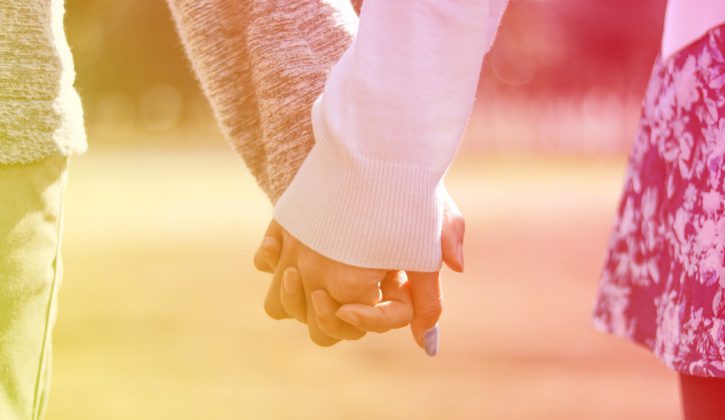 公園で手を繋ぐカップルの手元