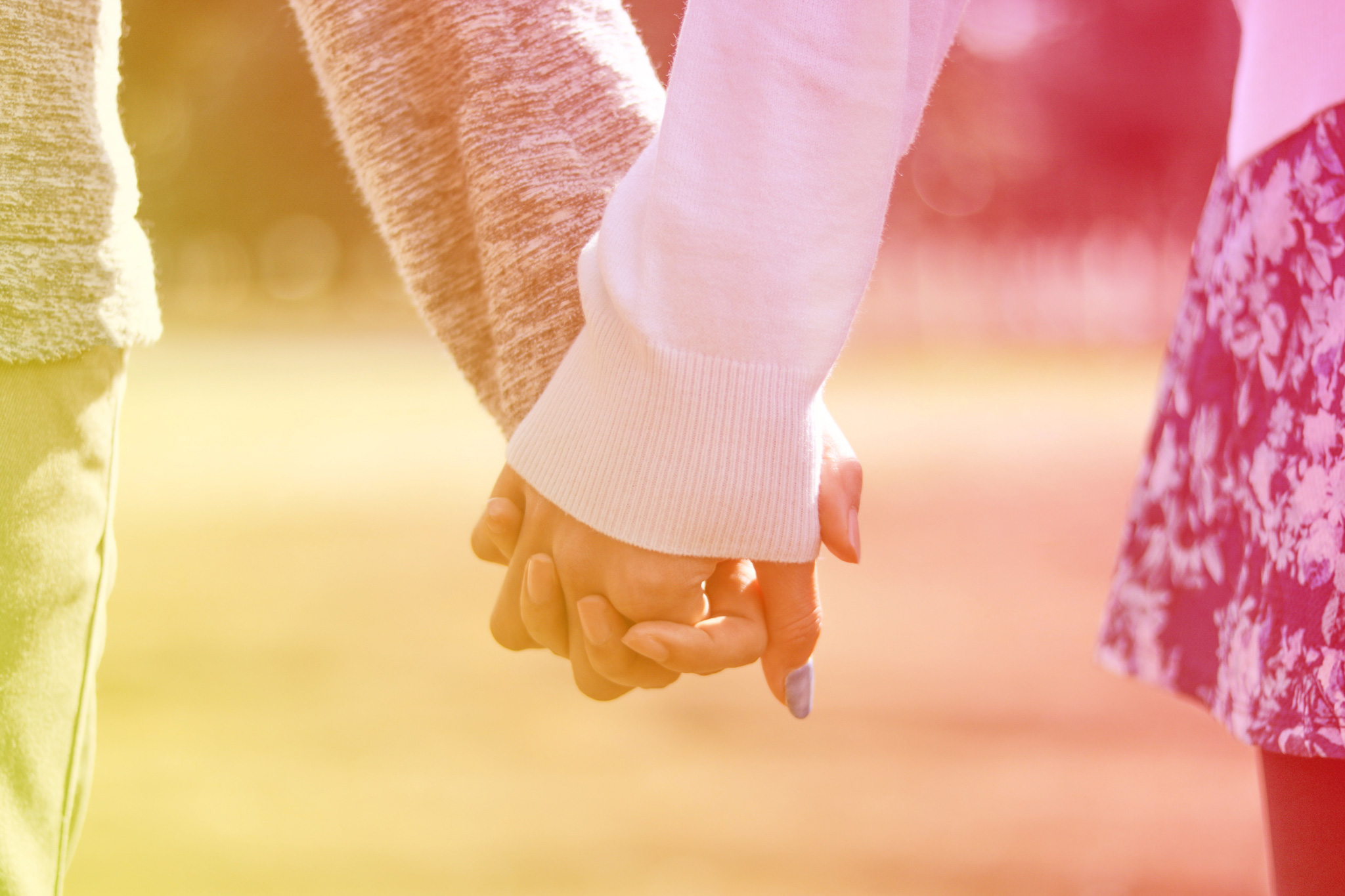 公園で手を繋ぐカップルの手元