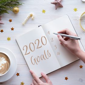 2020年の新年の目標をノートに書く女性