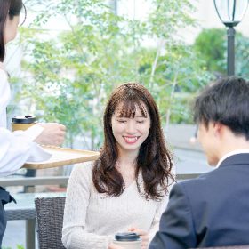 ガラス張りのカフェでデートするカップル