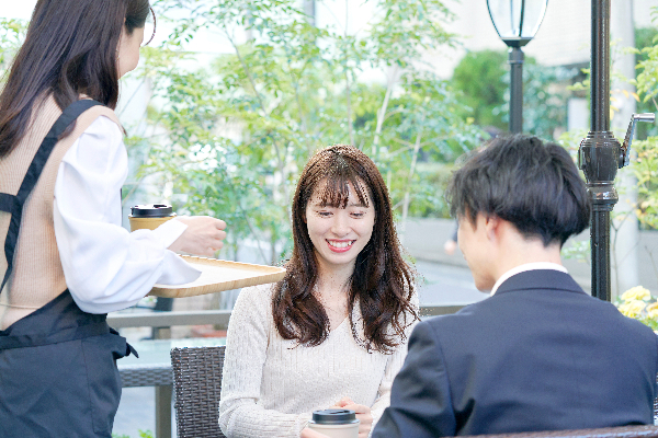 ガラス張りのカフェでデートするカップル