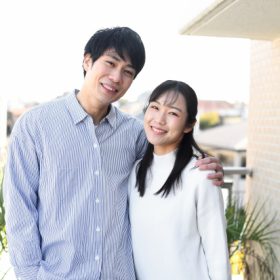 女性の肩を抱き寄せる男性