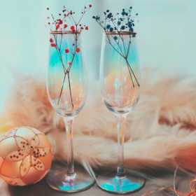 クリスマスオーナメントが置いてある机の上の2つの青い透明なシャンパングラス
