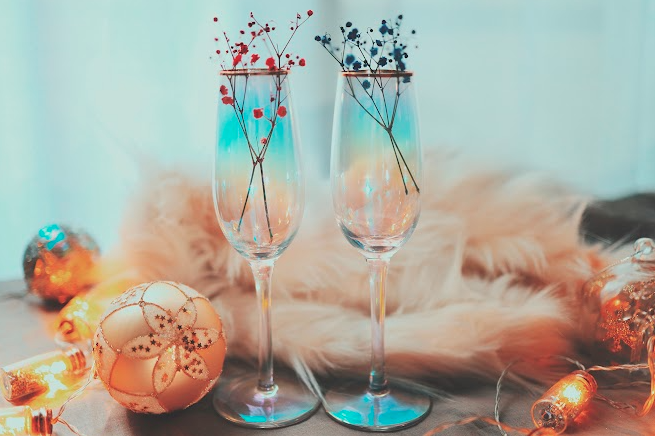クリスマスオーナメントが置いてある机の上の2つの青い透明なシャンパングラス