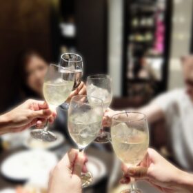 お酒の入ったグラスで乾杯する5人の女性