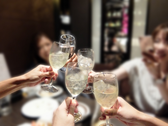 お酒の入ったグラスで乾杯する5人の女性