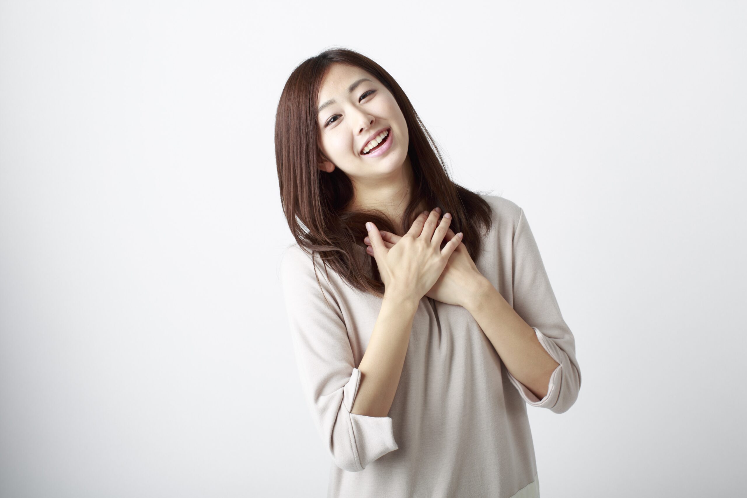 胸に手を当ててホッとした表情の若い女性